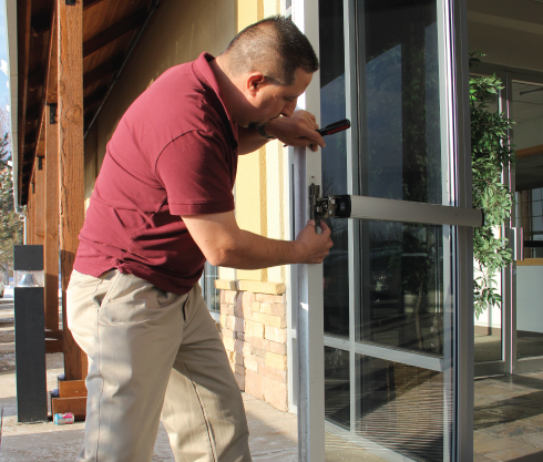ARD Locksmith technician installing commercial lock system on glass door in Little Rock, AR