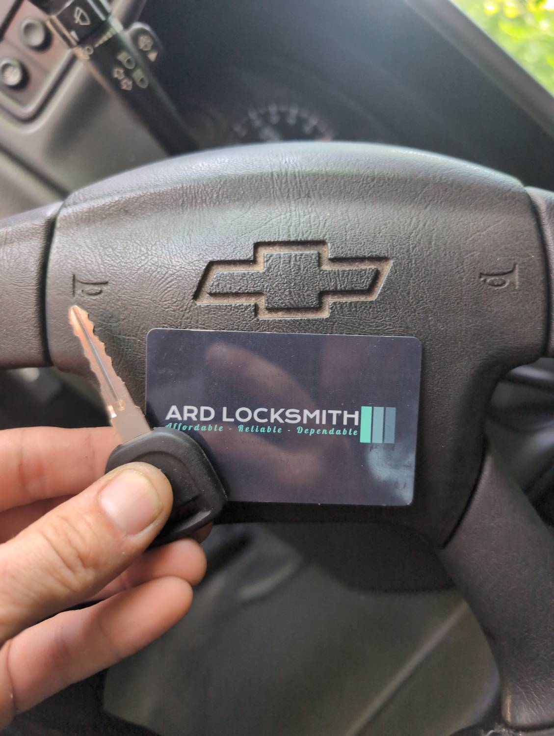 Completed Chevrolet Silverado replacement key documented inside the vehicle with an ARD Locksmith card