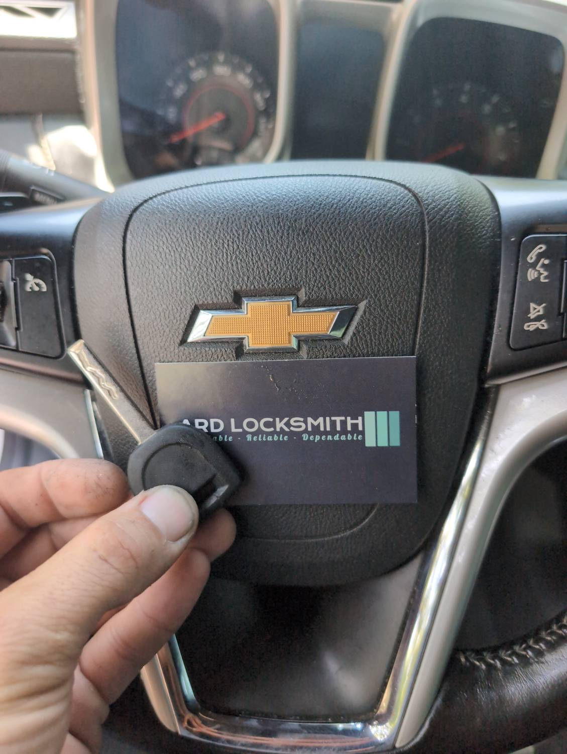 Completed Chevrolet key documented inside a Camaro with an ARD Locksmith card