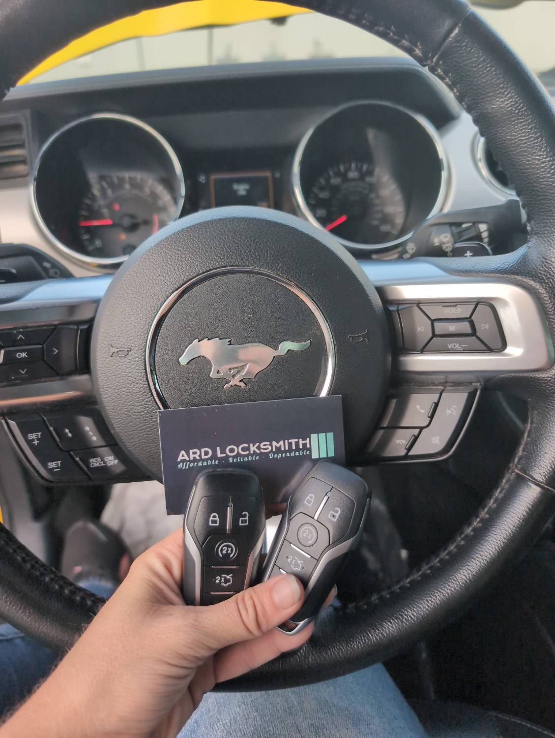 Two completed Ford smart keys documented inside a Mustang with an ARD Locksmith card