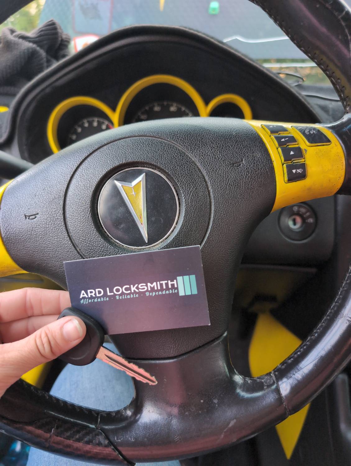 Completed Pontiac G6 replacement key documented inside the vehicle with an ARD Locksmith card