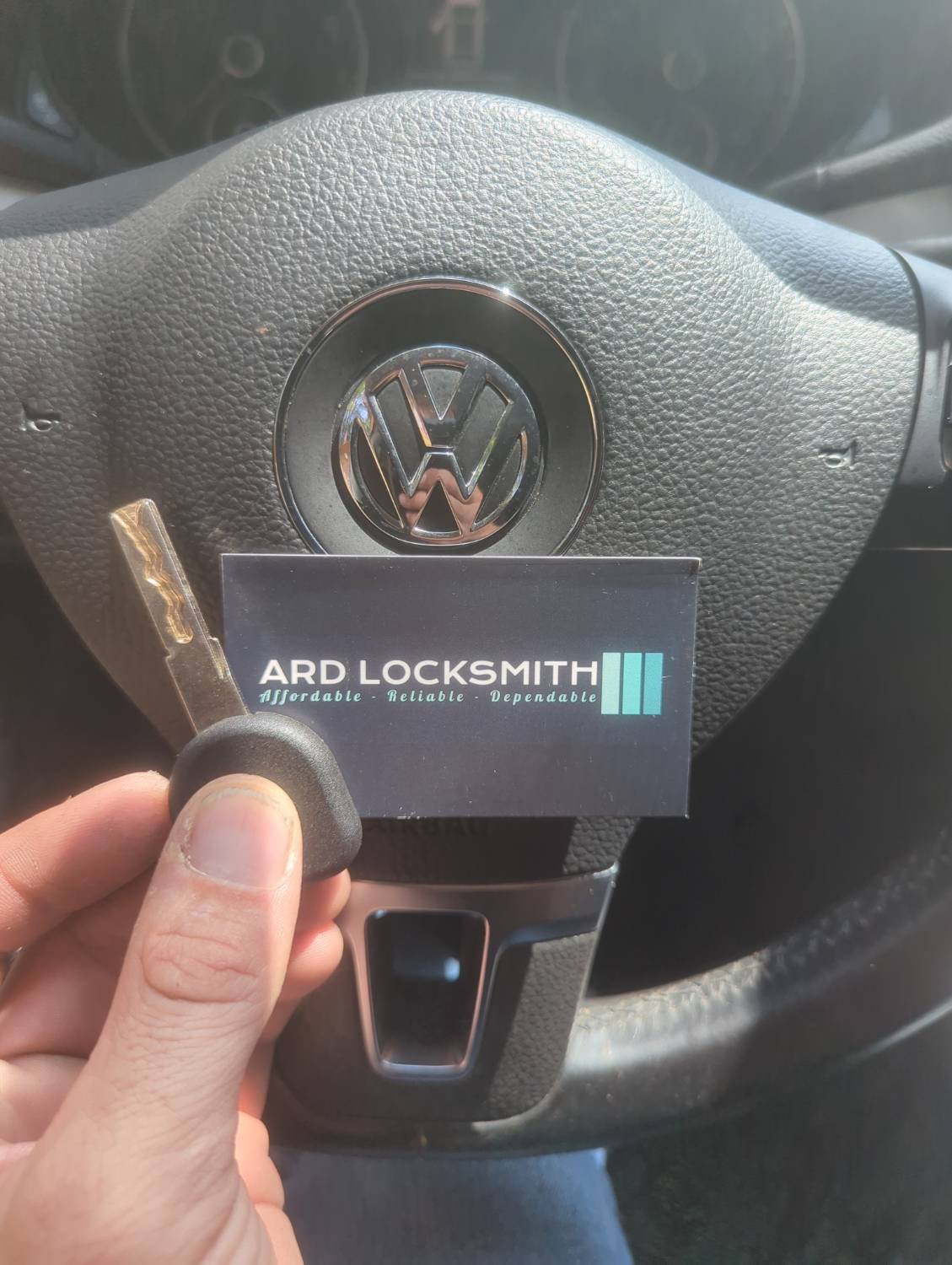 Completed Volkswagen Passat replacement key documented inside the vehicle with an ARD Locksmith card