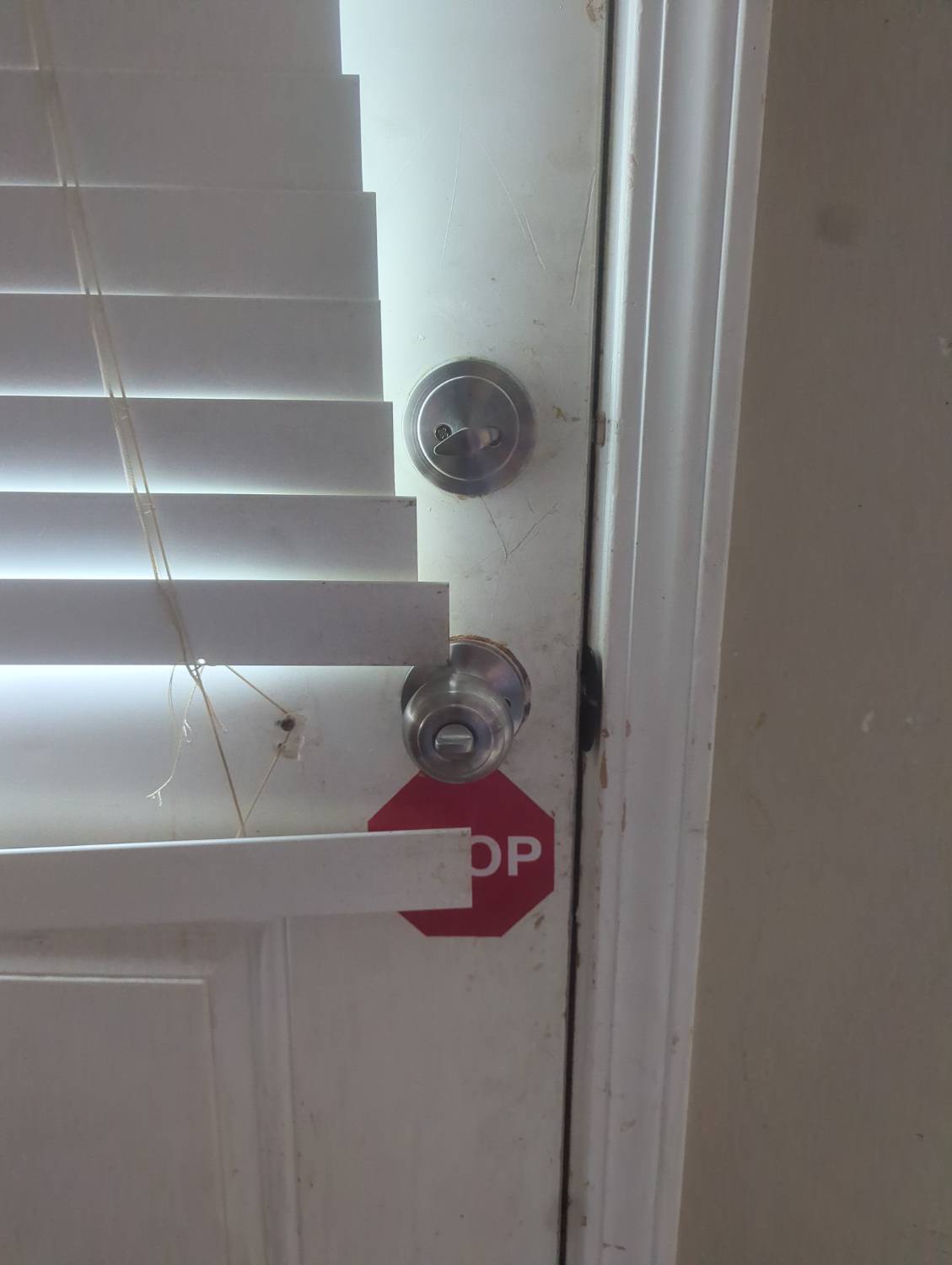 Replacement doorknob and deadbolt documented on a rental home door