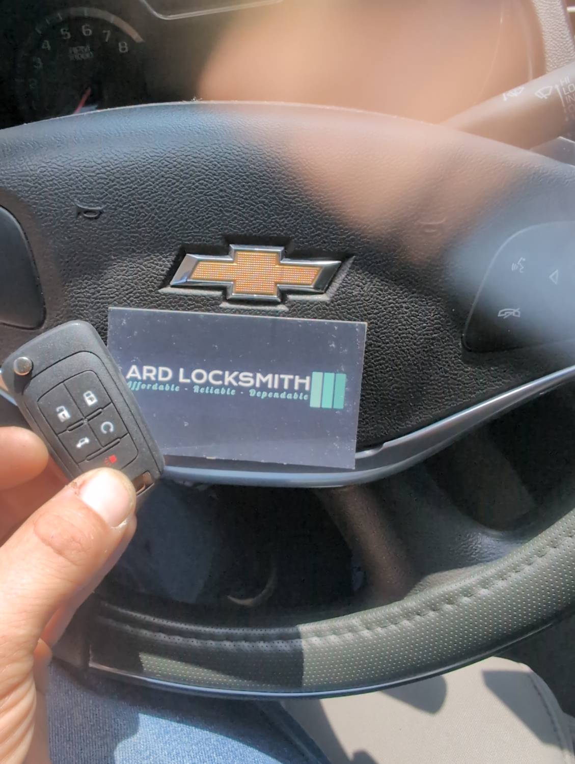 Completed Chevrolet flip key documented inside an Impala with an ARD Locksmith card