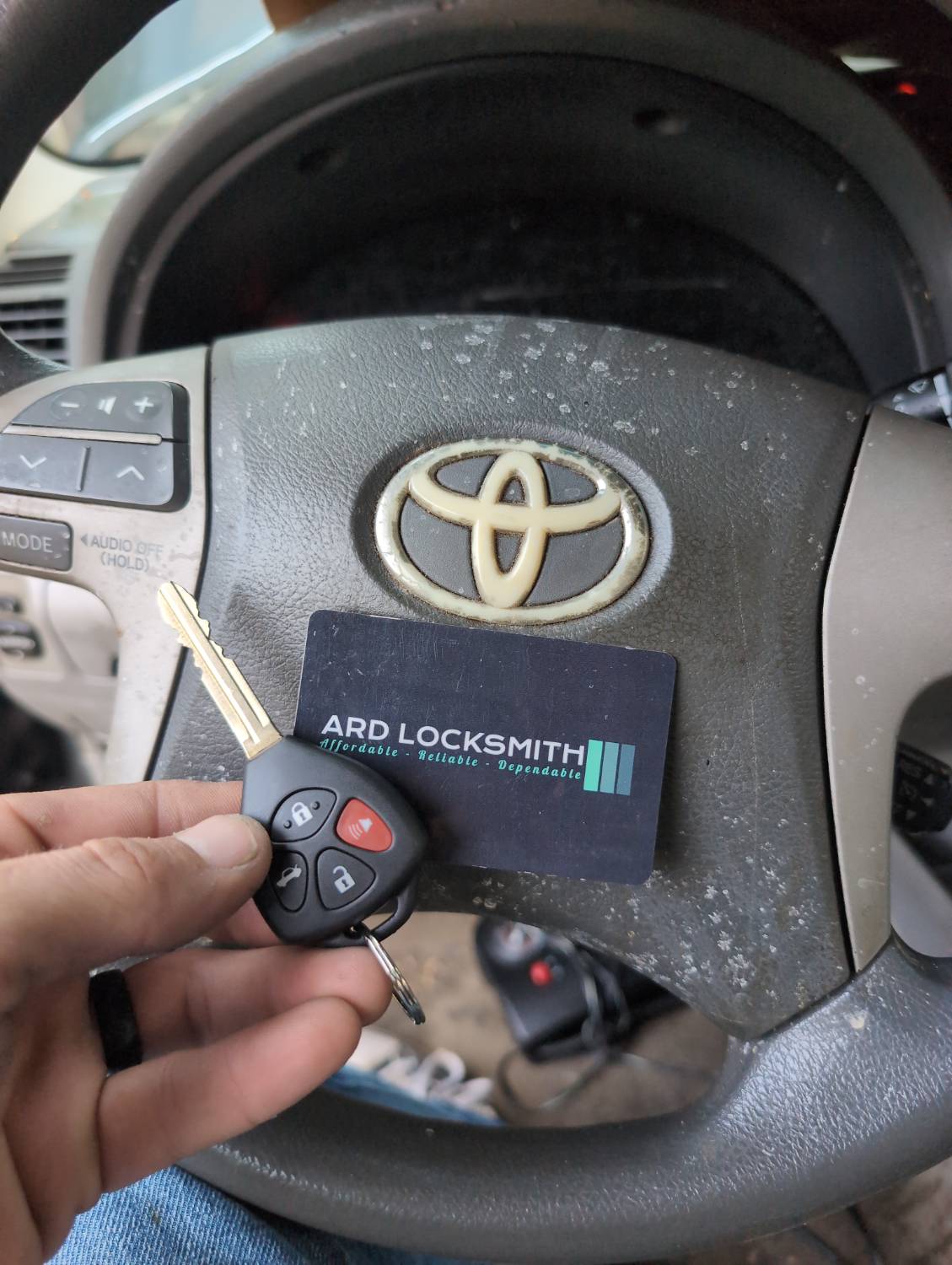 Completed Toyota Camry key copy documented inside the vehicle with an ARD Locksmith card