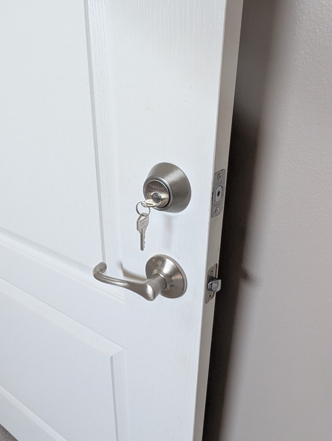 Installed residential deadbolt and lever with completed keys