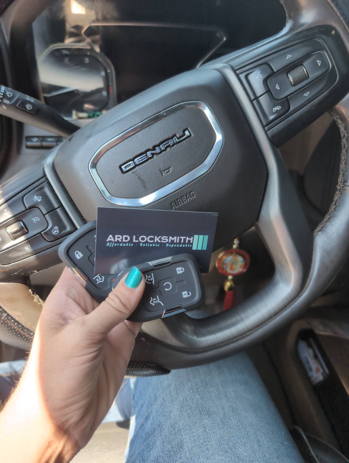 Two completed GMC Sierra smart keys documented inside the vehicle with an ARD Locksmith card