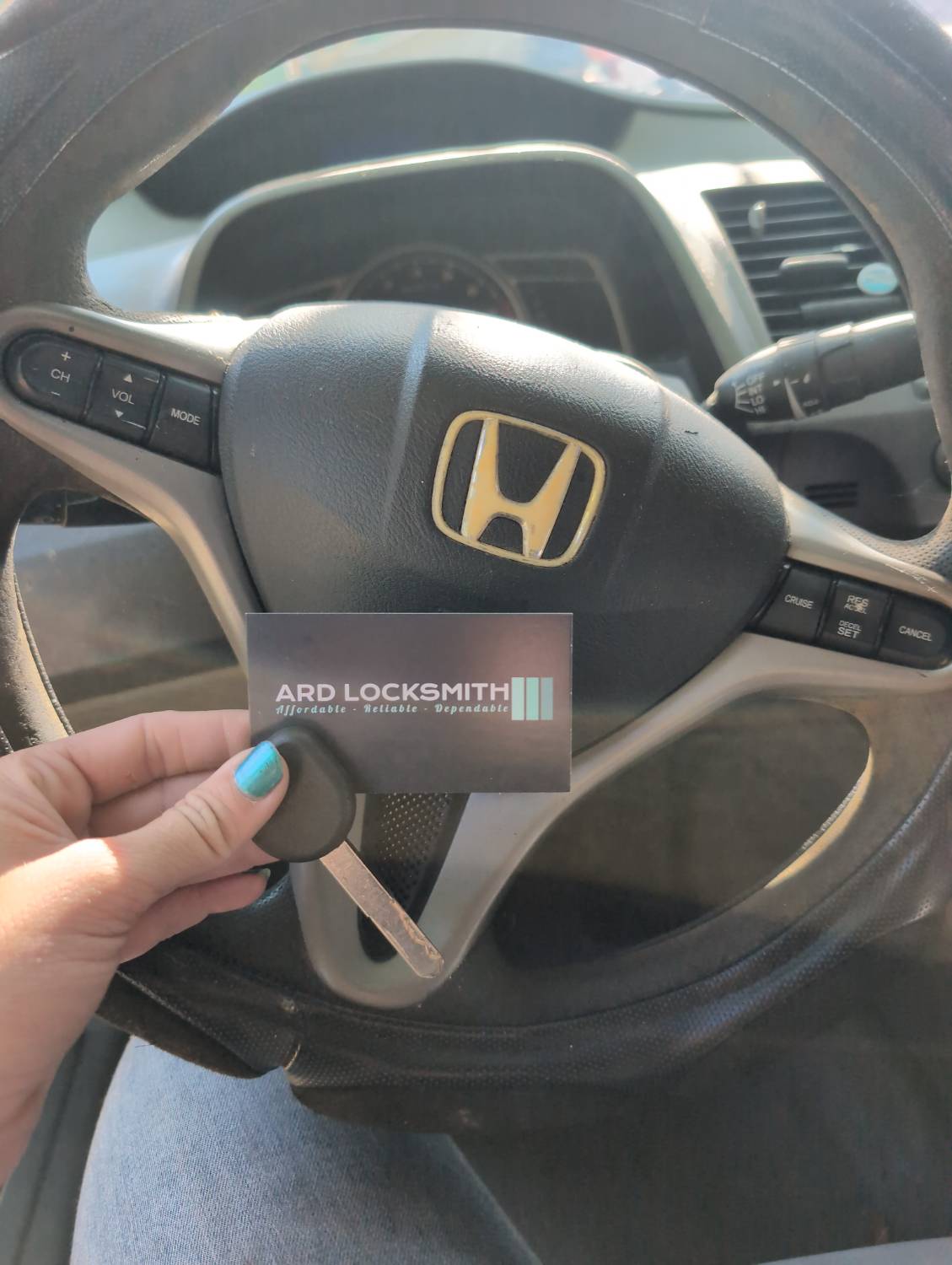 Completed Honda Civic replacement key documented inside the vehicle with an ARD Locksmith card