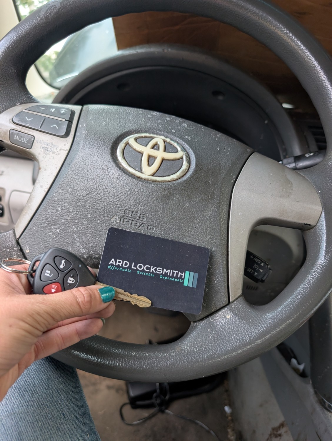 Completed Toyota Camry key copy documented inside the vehicle with an ARD Locksmith card