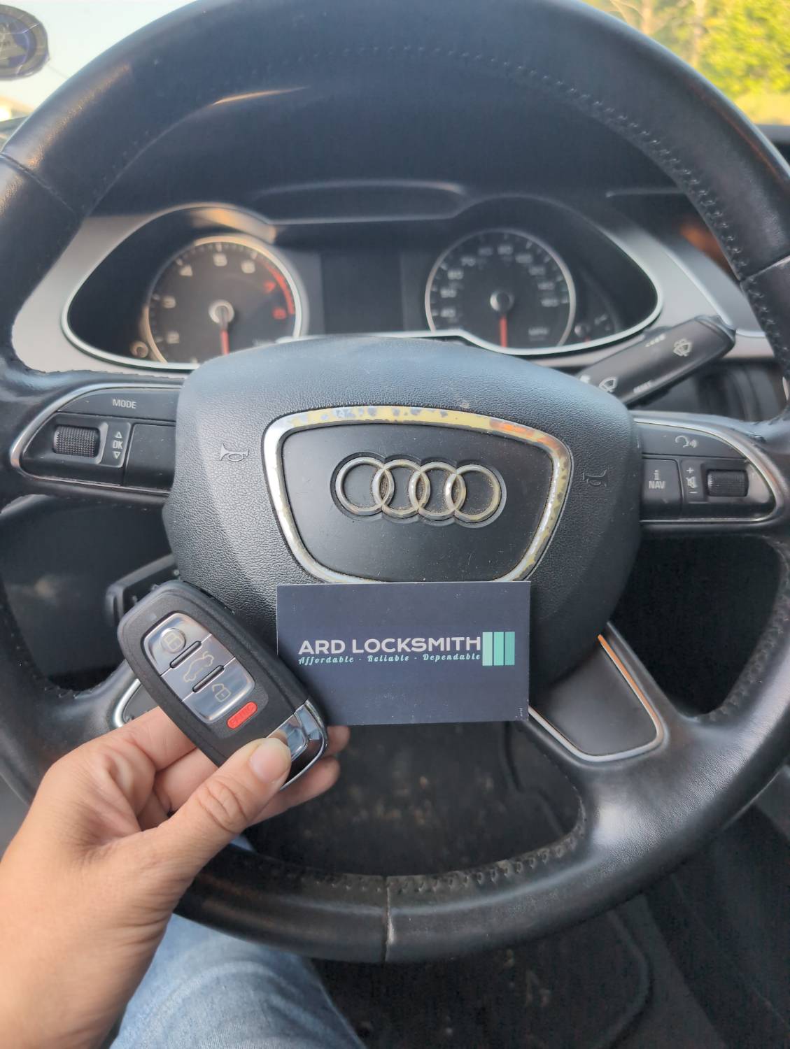 Completed Audi A4 key fob documented inside the vehicle with an ARD Locksmith card