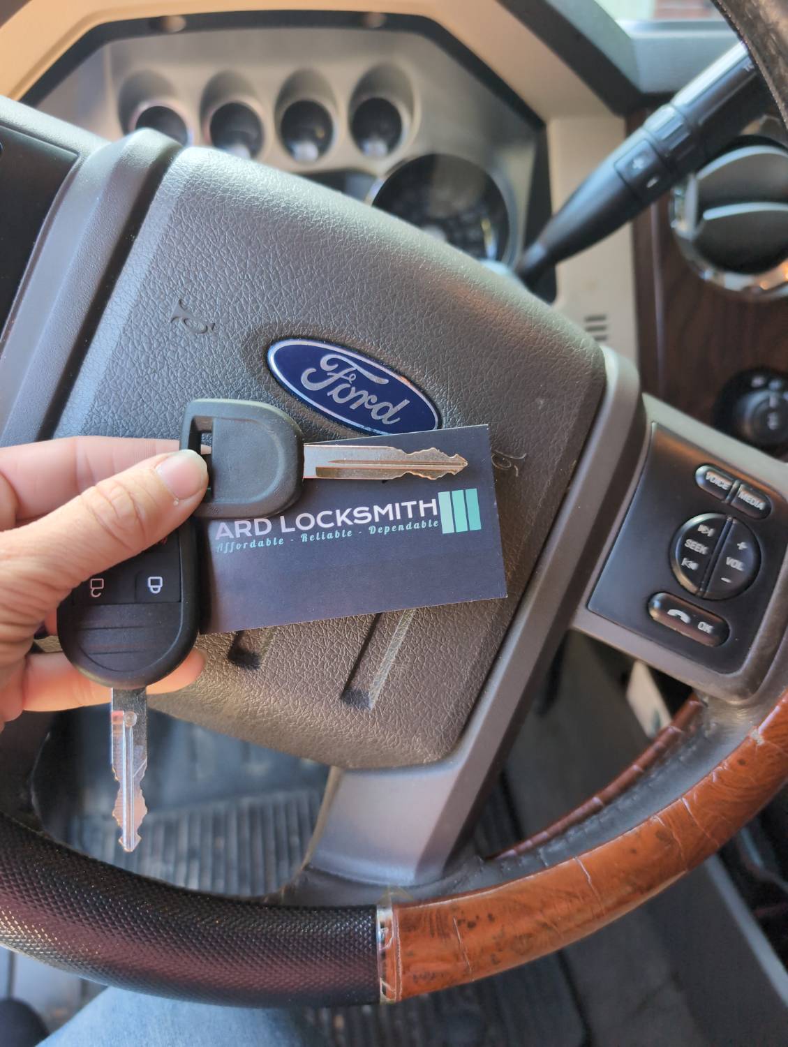Completed Ford F-250 replacement key documented inside the vehicle with an ARD Locksmith card