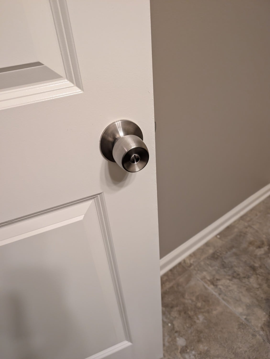 Replacement silver privacy doorknob installed on a white interior door.