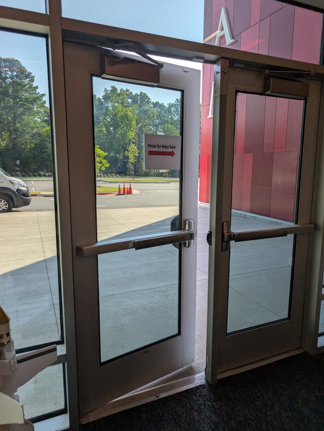 Commercial glass entry doors with panic bars and overhead door closers